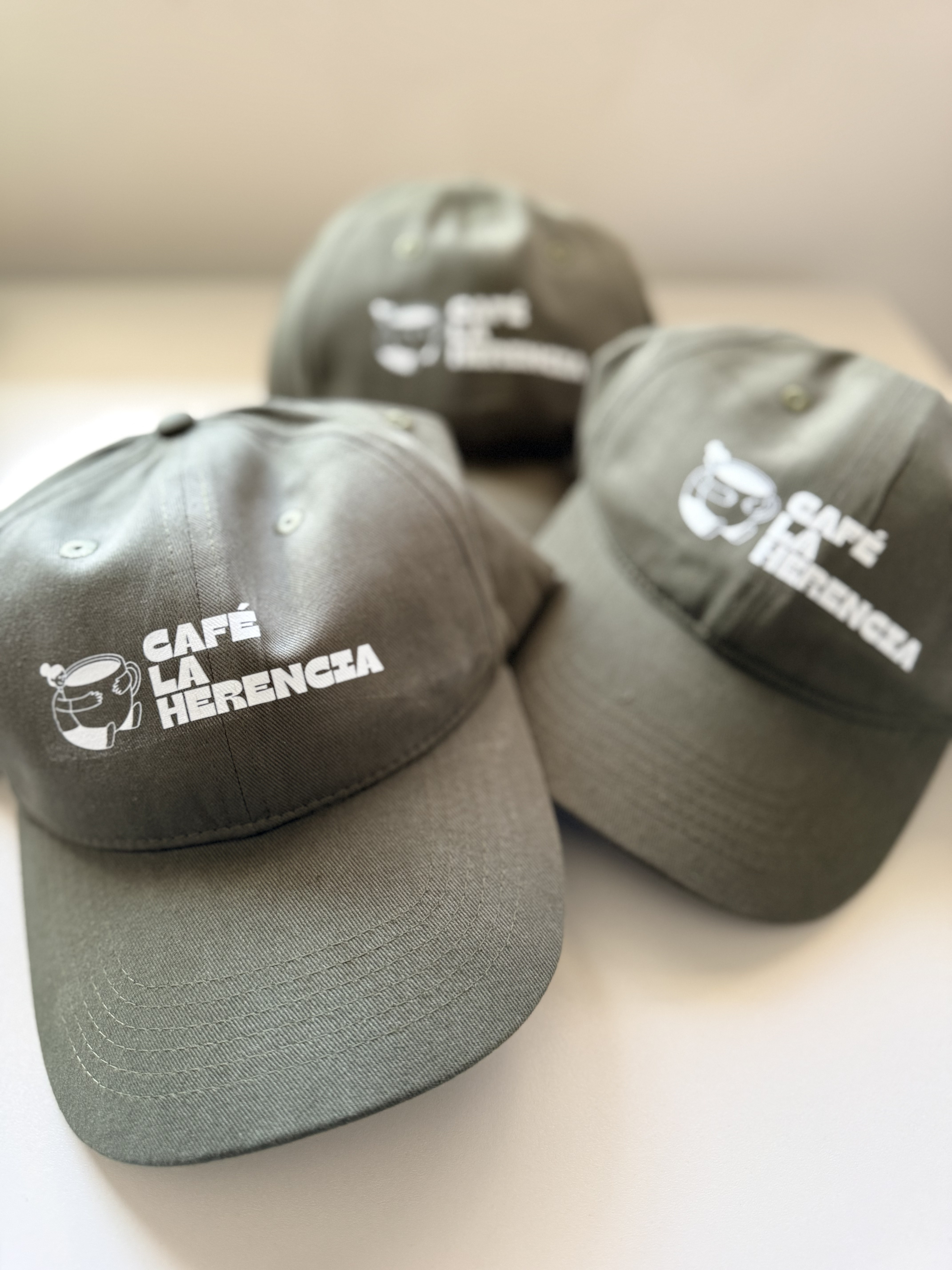 Gorras verde olivo Café La Herencia con logo blanco