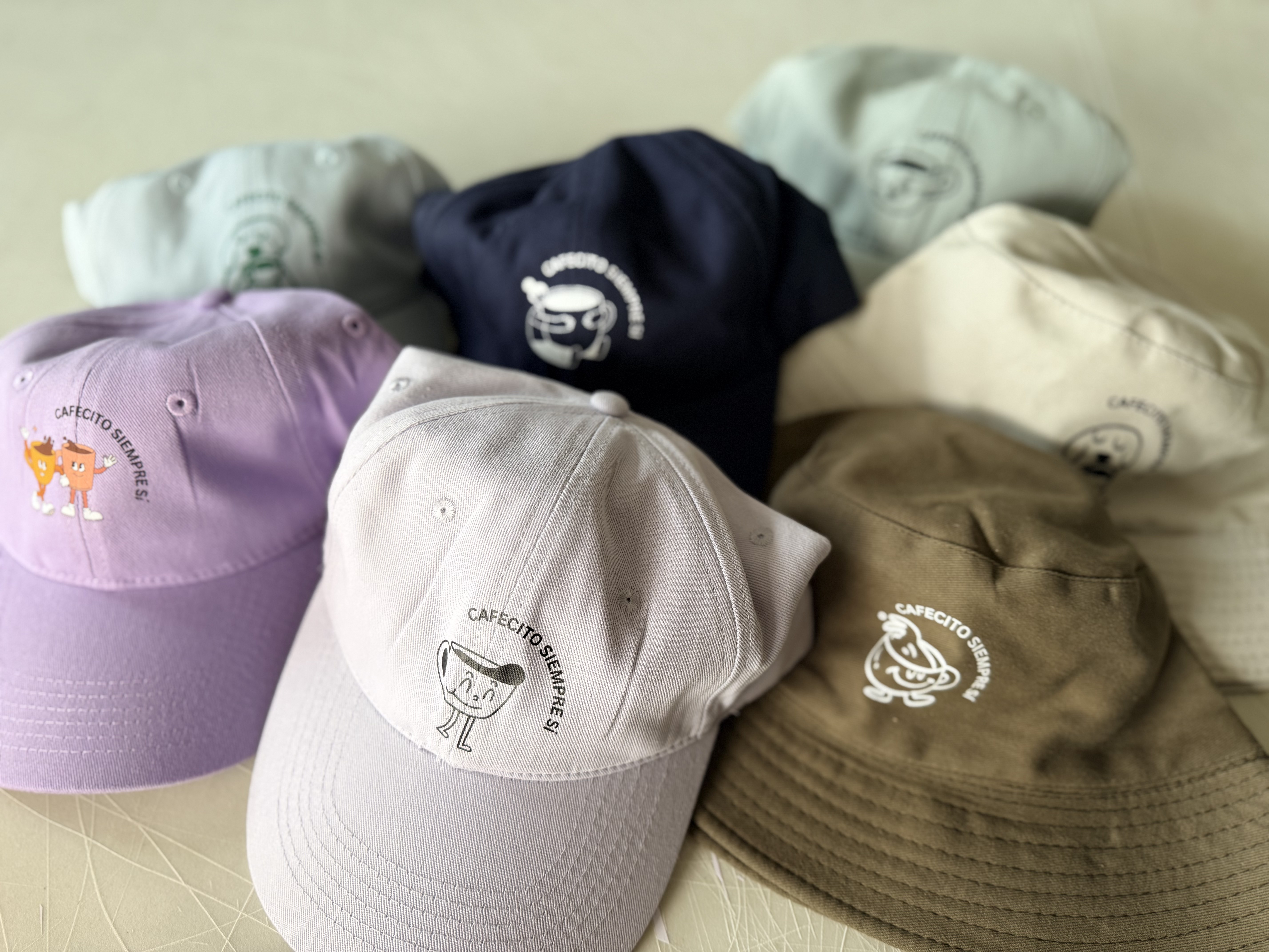 Gorras Cafecito Siempre Sí en varios colores con ilustraciones estampadas